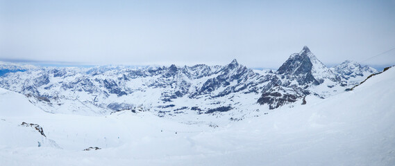 Stunning panoramic view of the Alps featuring the iconics Matterhorn and Klein Matterhorn surrounded by snow-capped peaks