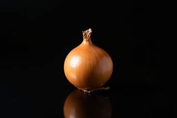 "Whole Brown Onion with Papery Skin Illuminated Against a Deep Black Background &ndash; A Study in Minimalist Food Photography"