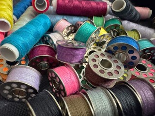  Close up photo of colorful sewing thread spools and bobbins