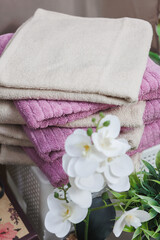 This aesthetic arrangement includes soft towels and an elegant orchid, perfect for enhancing home decor