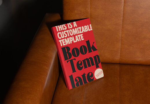 Mockup of Book Cover Resting on a Brown Leather Couch
