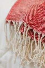 This warm red and white woven blanket with a soft fringe adds comfort and style to any desired space