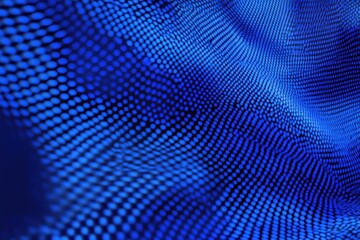 Fototapeta premium Abstract close-up of a textured blue surface featuring a pattern of dots, creating a dynamic visual effect that evokes a sense of motion and depth