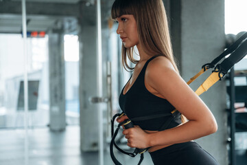 Process of training, exercise for arms. Young woman is in the gym