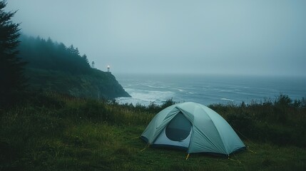 Obraz premium Misty coastal campsite with tent and lighthouse.