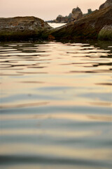 calm sea surface colored by the rays of the setting sun.