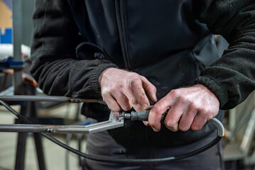Dans un atelier de métallerie, un technicien est en train de limer le métal. 