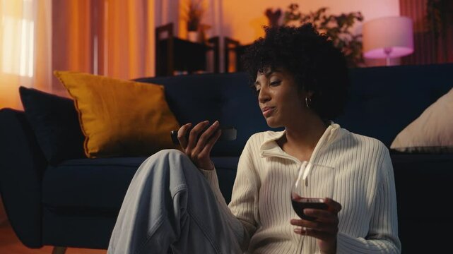 African American young woman calls her ex-boyfriend while drinking wine