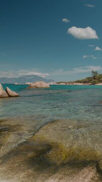 Vertical Screen: Mediterranean Sea coast with rocky under expansive cloudscape. Greek coastal landscape under bright summer sky.