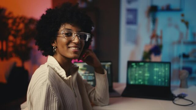 Portrait of smiling woman programmer coding on laptop, creative technology job