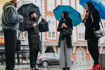 Business professionals brainstorming ideas while standing in an urban street on a rainy day,...