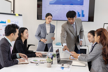 Group of business people working together with dashboard analysis and data management a meeting table in an office.