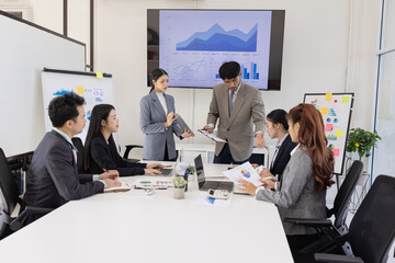 Group of business people working together with dashboard analysis and data management a meeting table in an office.
