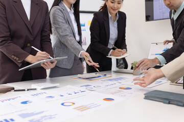 Group of business people working together with dashboard analysis and data management a meeting table in an office.