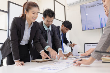 Group of business people working together with dashboard analysis and data management a meeting table in an office.