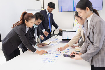 Group of business people working together with dashboard analysis and data management a meeting table in an office.