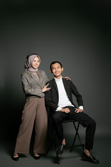 Modern and fashionable couple posing in a studio, exuding confidence and sophistication