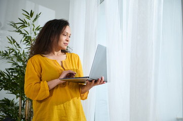 Smiling Businesswoman Using a Laptop in a Cozy Home Office Environment