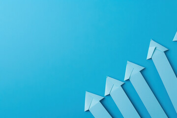 A blue background with five paper arrows pointing upwards