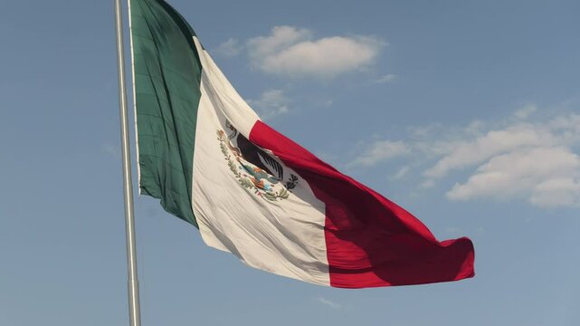 Mexican flag swaying in the wind on a beautiful day. Close up. Mexico City.
