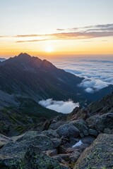 Sunrise over jagged mountain peaks with misty valleys