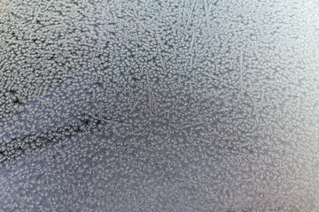 Texture of the hoarfrost on the side window of parked car