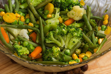 Different boiled vegetables in glass salad bowl, fragment close-up