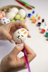 Female hand painting with easter eggs. girl coloring easter egg