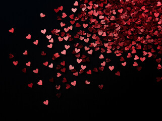 A flat lay featuring small red hearts on a black background, creating a love-themed composition with heart shapes arranged thoughtfully to highlight a romantic atmosphere
