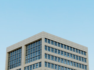 Modern architectural building with windows and geometric edges against clear skies.