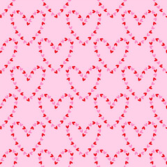 Seamless pattern with bright hearts in pink and red colours on a light pink background. Vector Valentine's Day background. Editable.