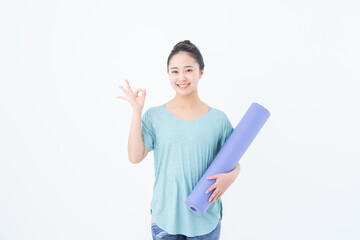 ヨガマットを持つ若い女性