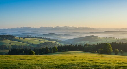 Obraz premium Idyllic Green Meadow Landscape with Distant Mountains and Hazy Valleys