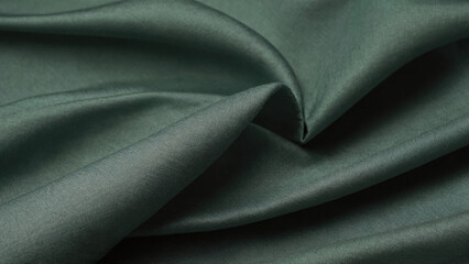 A emerald green linen fabric background. Luxurious emerald green linen fabric with soft folds. Green linen texture.