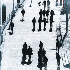 silhouettes and shadows of people walking through the streets of Bilbao
