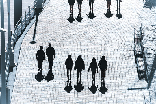 silhouettes and shadows of people walking through the streets of Bilbao