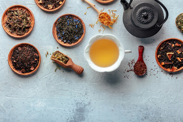 Loose tea leaves. Black, green, white tea, an assortment, with flowers, herbs, and fruit, and a tea cup and pot, overhead flat lay shot with copy space