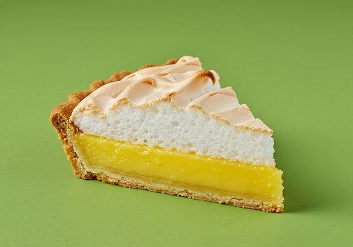 A Slice of Lemon Meringue Pie on Green Background