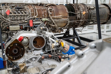 A large engine is sitting in a hangar with other engines. The engine is old and rusty, and it is in...