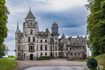 Fototapeta premium Dunrobin Castle, fairy-tale gem overlooking North Sea, offers breathtaking gardens, exquisite summer blooms. A masterpiece of elegance, lush landscapes meet historic charm, unfold on manicured lawns.