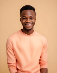 Young Nigerian man in fashionable attire, smiling with warmth, captured against a neutral background