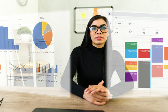 Professional woman wearing ar glasses analyzing work data, calendar, and metrics through immersive mixed reality interface - Powered by Adobe