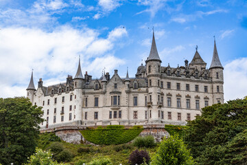 Fototapeta premium Dunrobin Castle, fairy-tale gem overlooking North Sea, offers breathtaking gardens, exquisite summer blooms. A masterpiece of elegance, lush landscapes meet historic charm, unfold on manicured lawns