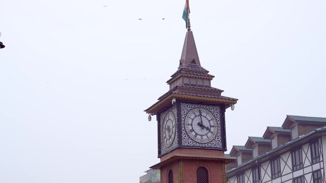 Close up shot of top of ganta ghar clock tower at Lal chowk red square in Srinagar kashmir with birds flying around showing this historic site and landmark which has historically held the tricolor