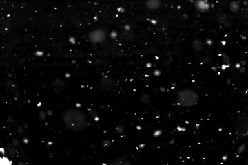 Texture of natural falling snow on black background.