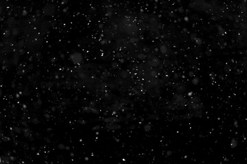 Texture of natural falling snow on black background.