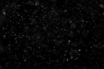 Texture of natural falling snow on black background.