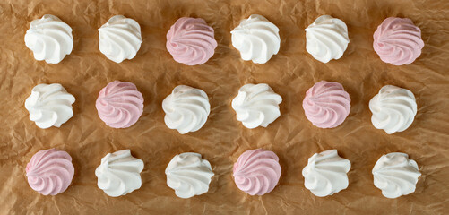 White and pink meringue cookies pattern top view. Traditional whisk merengues