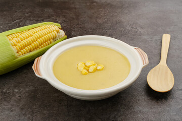 Creamy corn soup in ceramic bowl on the table. Vegetarian food
