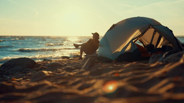 Happy man relaxing on sea beach alone, admire sunset above water, local tourism. Backpacking and camping on coastline, relishing silence and calmness, meditation and contemplation, camping on beach